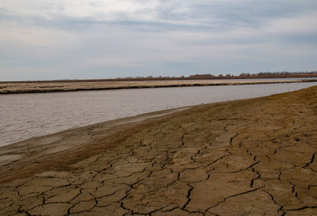 Banks of the Irtysh River in early autumn. Cracked soil on the banks of the Siberian Irtysh River