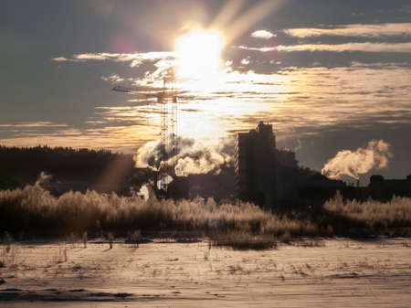 Industrial landscape in Khanty-Mansiysk. Smoke and steam over the frozen outskirts of the capital of the Khanty-Mansiysk Autonomous Okrug - Yugra, Khanty-Mansiysk. Industry and cities in the North.の写真素材