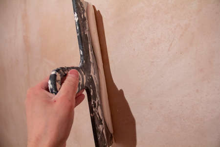 puttying. putty preparation. Mixing mortar for wall putty during repairs.の写真素材