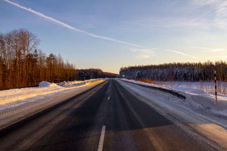 Winter track in the Siberian taiga. An icy winter highway runs through the snow and taiga. A section of the highway in the Khanty-Mansi Autonomous Okrug - Yugra between Khanty-Mansiysk and the city ofの写真素材