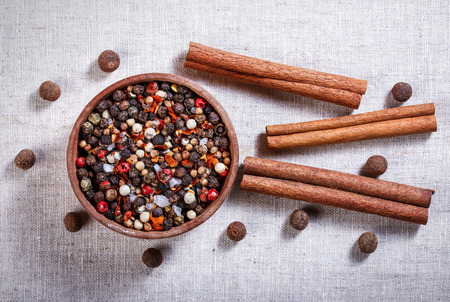 Spices in a wooden bowl, ceramic spoon, pepper, thyme, cinnamon, chili pepper, allspice.の写真素材