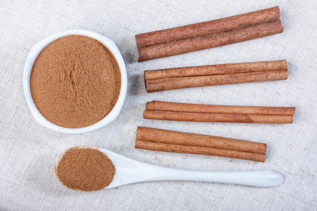Powdered cinnamon in a ceramic bowl, cinnamon, close-up, ceramic spoon, photo.の写真素材