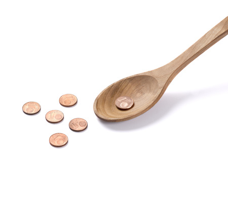 Coins on a wooden spoon. Saving money for youの写真素材