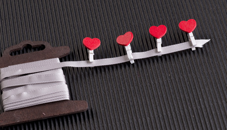 Red hearts. Small wooden clothespins. Gift ribbon.の写真素材