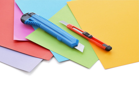 Sheets of colored paper and small stationery knife.の写真素材