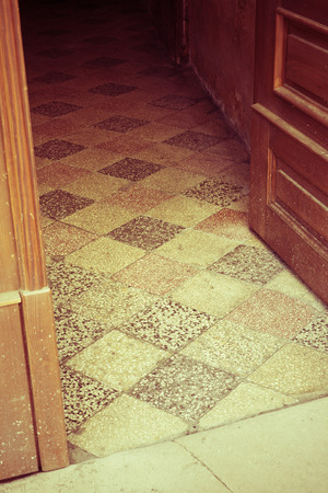 Old doors, handles, locks, lattices and windows. View of the Italian tile floor through the open door. Retro effect.の写真素材