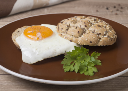 Sandwich with a fried egg on a wooden table dark.の写真素材