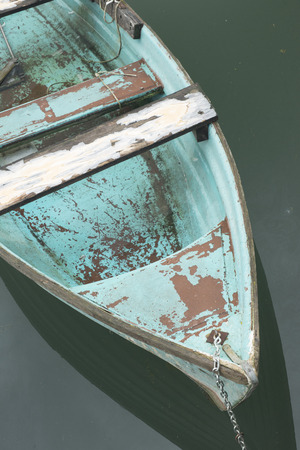 Old blue wooden boat on the lake near the shore.の写真素材