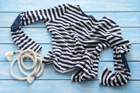 Frock and rope on a blue shabby wooden table.の写真素材