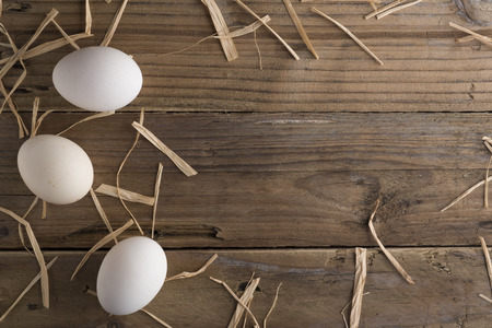 White eggs on old wooden table. Peasant life.の写真素材