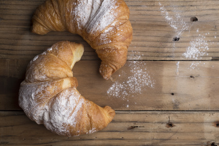 Fresh golden croissants on wooden table. Country style.