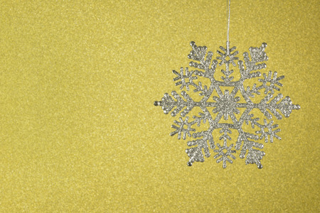 Shimmering diamond beautiful snowflakes on a yellow background.の写真素材