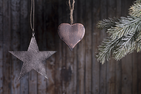 Christmas toys hanging on a branch of a Christmas tree on a wooden background.の写真素材