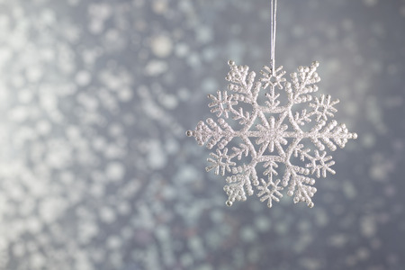 Silver diamond sparkling snowflakes on a silver background bokeh.の写真素材
