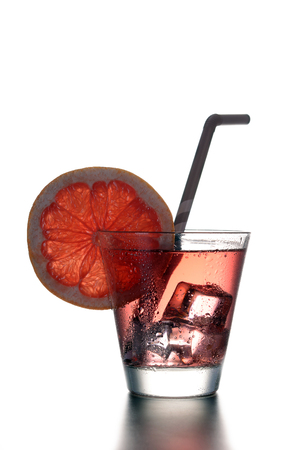 Fresh cocktail with grapefruit, ice and striped drinking straw on a white background.の写真素材