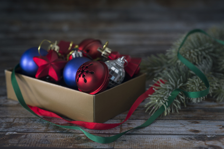 A box of Christmas decorations on an old wooden table.の写真素材