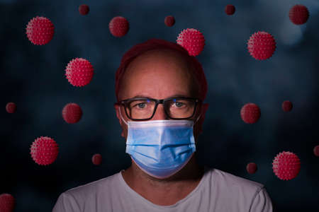 A man in a white t-shirt of a doctor, in a blue face mask among the covid-19 virus