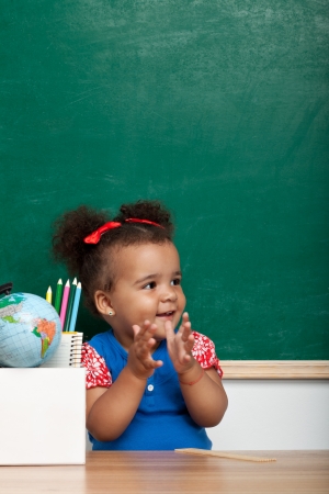 Cheerful smiling child  girl  at the blackboard  School conceptの写真素材