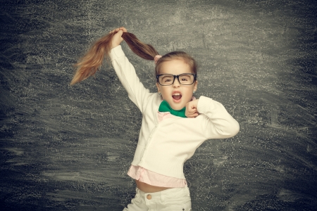 Beautiful smiling girl on a black background. School conceptの写真素材