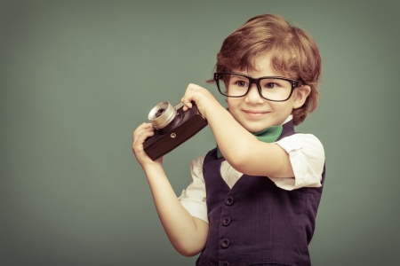 Cheerful  smiling  child (boy) holding a instant camera の写真素材