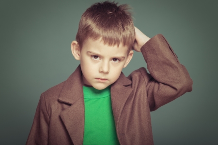 Cheerful smiling boy on a green background.の写真素材