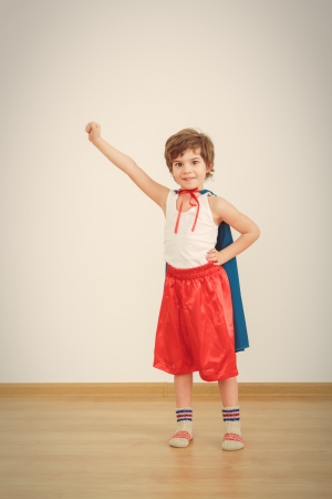 Funny little power super hero child (boy) in a blue raincoat.  の写真素材