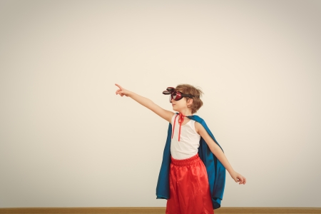 Funny little power super hero child (boy) in a blue raincoat. の写真素材