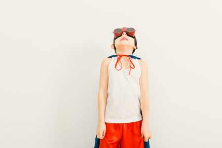 Funny little power super hero child (boy) in a blue raincoat.  Superhero conceptの写真素材