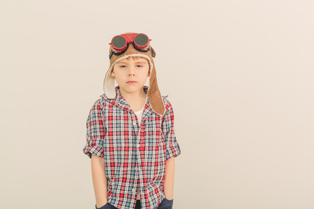 Cheerful smiling kid  boy l in helmet on a green background  Vintage pilot  aviator  conceptの写真素材