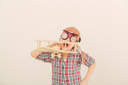 Cheerful smiling kid  boy l in helmet on a green background  Vintage pilot  aviator  conceptの写真素材