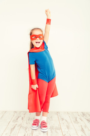 Funny little power super hero child (girl) in a blue raincoatの写真素材