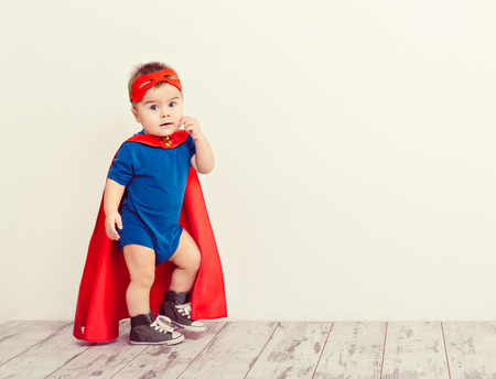 Funny little power super hero child (boy) in a blue raincoatの写真素材
