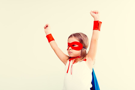 Funny little power super hero child (girl) in a blue raincoatの写真素材