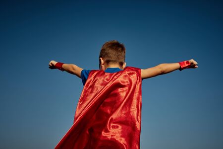 Funny little power super hero child (boy) in a red raincoat. Superhero concept.の写真素材