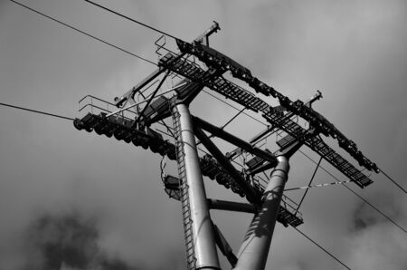 Steel cableway pylon against a background of clouds in monochrome.の写真素材
