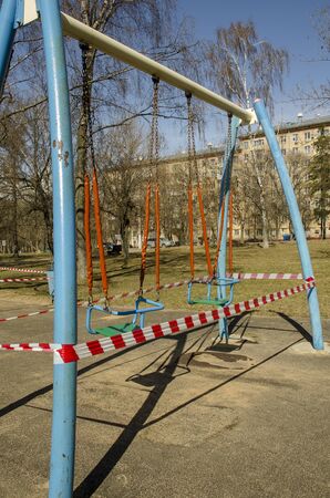 Children's swing surrounded by a police tape.の写真素材