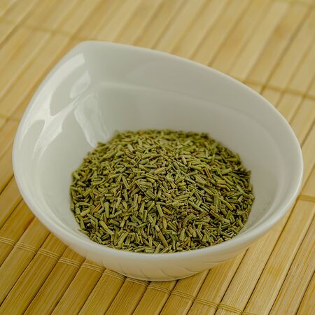 Rosemary seasoning in a white bowl close-up.の写真素材