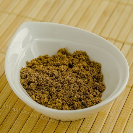 Seasoning ground coriander in a white bowl close-up.の写真素材