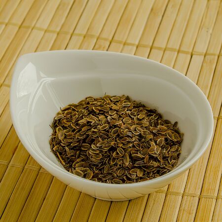 Seasoning dill seeds in a white bowl close-up.の写真素材