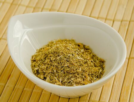 Seasoning dried chamomile in a white bowl close-up.の写真素材