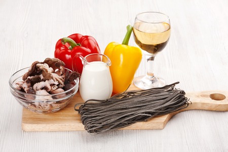 Ingredients for cooking pasta with seafood on a cutting boardの写真素材