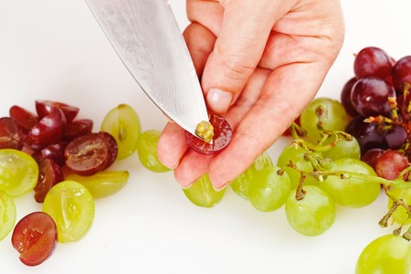 separation of seed from ripe grapes with a knife closeupの写真素材