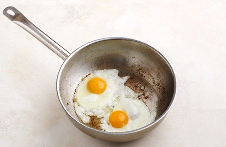 Two fried eggs in a pan close-up. Scrambled eggsの写真素材