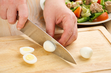 the process of cutting boiled quail eggs on a cutting board closeup