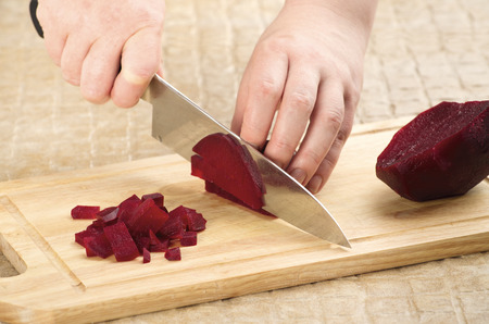 process of cutting the boiled beets on a cutting board closeupの写真素材