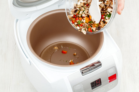 cooking fried vegetables and mushrooms in multicooker closeupの写真素材