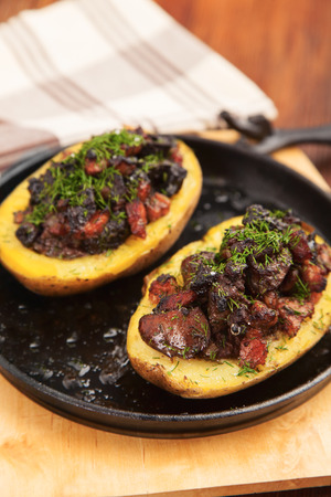 Baked potatoes stuffed with meat on a frying pan closeupの写真素材