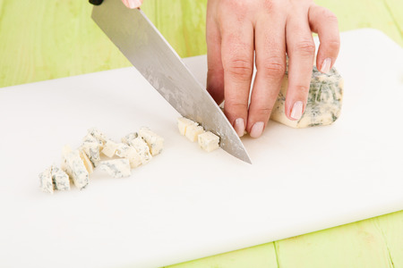Chef cuts the blue cheese on a cutting board closeupの写真素材