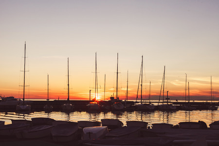 Beautiful port for luxury yachts in the rays of the setting summer sun. Sunset at the port for yachts. Yacht clubの写真素材