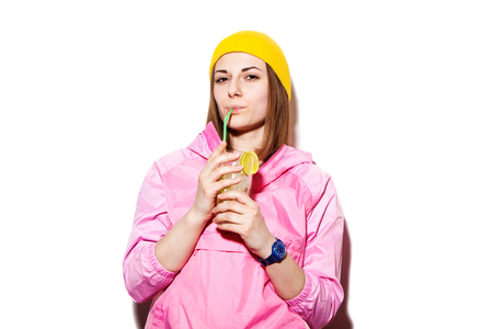 Attractive hipster woman cocktail drink gin and tonic indoors. Sexy girl a pink jacket and refreshing cocktail drinksの写真素材